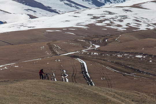 Cyclist on a Snowy Mountain Trail.