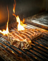 Close up of a grilled beef steak on a barbecue grill with flames