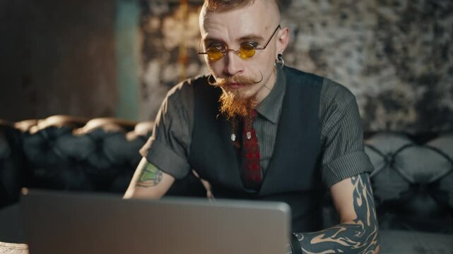 Handsome steampunk style man reading news in internet by computer, portrait. Shocked and amazed male person examining information on website, online education and business, rich businessman using PC