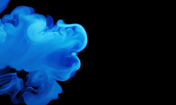 Abstract blue smoke blowing around black background.