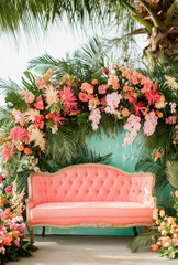 Fototapeta premium Pale Coral Sofa on a Wedding Stage Adorned with Soft Roses and Subtle Golden Highlights