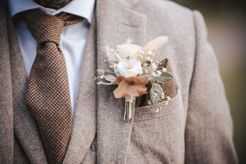 A close up of the grooms buttonhole flower on his wedding day