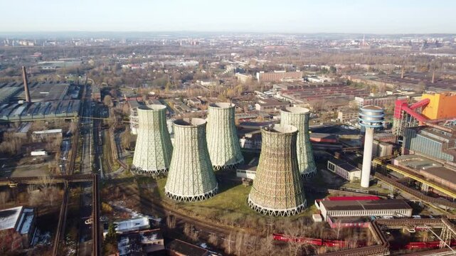 Non-functioning Hyperboloid Cooling Towers At Power Plant. - aerial pullback shot