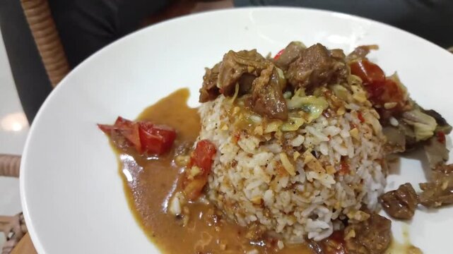 Traditional homemade mutton curry from Indonesian, Asian cuisine. Delicious and spicy beef curry. A plate of mutton with abundant spices with rice.