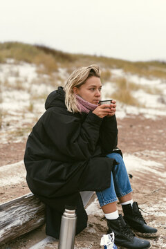 Young woman on the shore of the cold Baltic sea in winter in Latvia