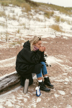 Young woman on the shore of the cold Baltic sea in winter in Latvia