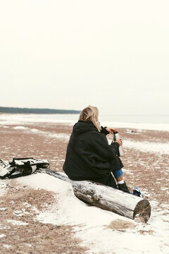 Young woman on the shore of the cold Baltic sea in winter in Latvia