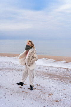 Young woman on the shore of the cold Baltic sea in winter in Latvia