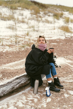 Young woman on the shore of the cold Baltic sea in winter in Latvia