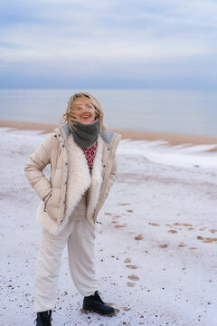 Young woman on the shore of the cold Baltic sea in winter in Latvia