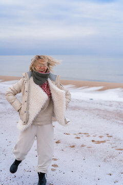Young woman on the shore of the cold Baltic sea in winter in Latvia