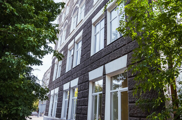 Intricate balconies and ornamental features of a historic structure in Irkutsk are highlighted under blue skies.