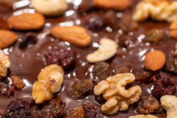 Stockholm, Sweden Melted chocolate on wax paper with nuts and raisins to make chocolate candies.