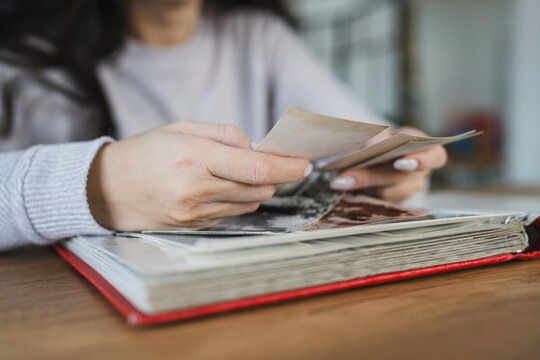 close up of woman look at photos for family photo album