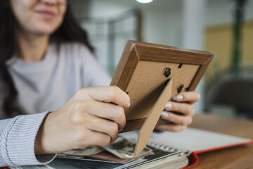 close up of woman look at photos in picture frame