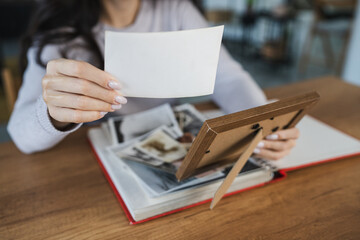 close up of woman look at photos in picture frame