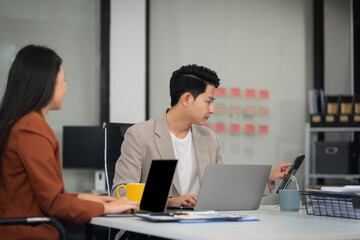 financial asian advisor showing plan of investment to clients in the consultancy office.