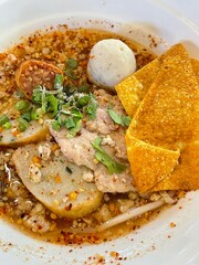 The closed up of Thai noodles with meat ball. Select and soft focus. Asian noodle soup with beef meatball with fresh vegetable on wood table. Hot and spicy noodle soup, Asian food.
