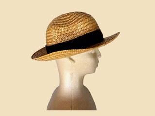 The white background in the picture is a brown hat woven from a type of dry grass that is tough and resistant to sunlight. It is detailed with beautiful patterns and has a black cloth in the middle.