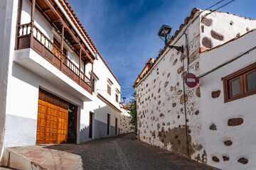 Alley in Santa Lucia de Tirajana on the island Gran Canaria, Canary Islands, Spain. Palm trees and mountains in the background.
