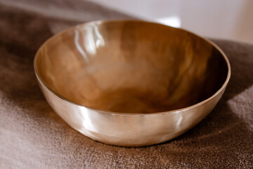 Tibetan singing bowl in a spa salon against the beige textile backdrop. Sound therapy, recreation,...