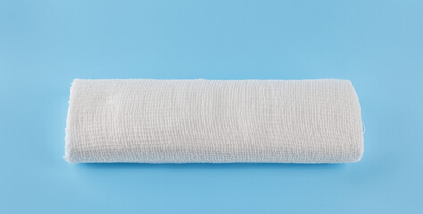 Gauze medical bandage on a blue background. Roll of bandage.