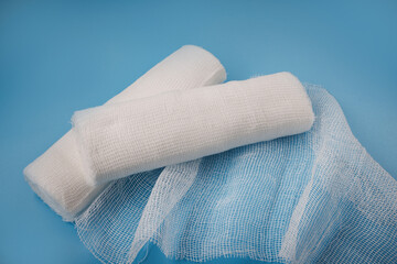 Gauze medical bandage. Two rolls of bandage on a blue background. Unwound bandage.