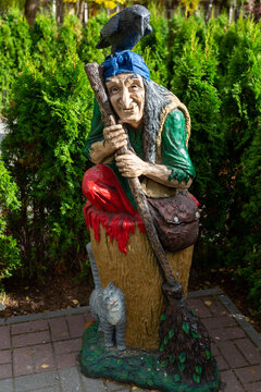 Wooden figure of Baba Yaga in the park against the background of trees