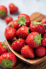 Fresh juicy strawberries in wooden bowl closeup view, seasonal summer berry fruits rich in vitamin C