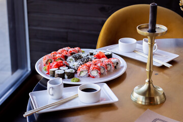 Table with Sushi Plate, Chopsticks, Soy Sauce and Saucer, Candle, and Yellow Chair