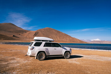 Obraz premium Tibet,China - December 17,2024: Driving off road car in high altitude mountains in tibet, China