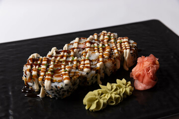 Salmon skin sushi roll served on a black stone, top view
