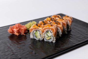Salmon skin sushi roll served on a black stone, top view
