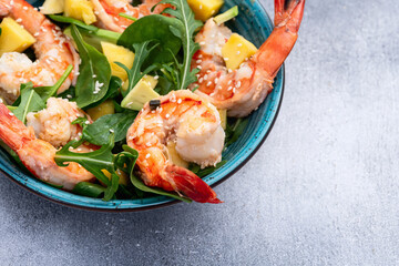Salad with tiger shrimps , avocado and mango . Top view
