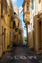 a beautiful iconic cityscape view through the small and the narrow streets of Mdina, Malta. With lots of power cables 