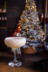 Coconut Cocktail with Dried Coconut Pieces Against a Blurred Background of a New Year’s Tree