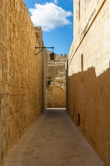 Fototapeta premium a beautiful iconic cityscape view through the small and the narrow streets of Mdina, Malta. 