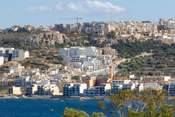 Naklejka premium a beautiful cityscape view of Mellieha with the coastline of Mellieha Bay in Malta