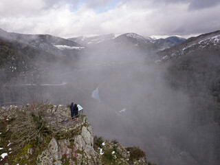 Couple in the mists at the Aritztoki Viewpoint, Aezkoa Valley. Winter panorama