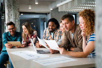 Group of young multi-ethnic startup business team collaborating on project in modern office
