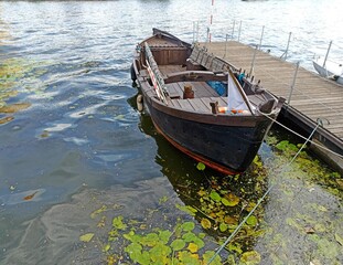 a wooden boat moored to a wooden pier