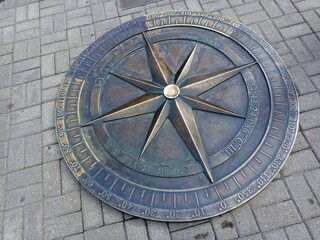 a large metal compass embedded in the sidewalk. Kaliningrad 2024 July 17