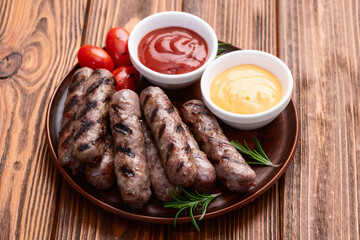 Grilled beef sausages with rosemary sauce and tomatoes photography . Top view