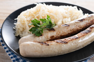 Bratwurst sausage and sauerkraut on wooden table. Close up