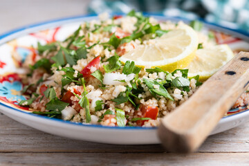 Tabbouleh salad with couscous on wooden table