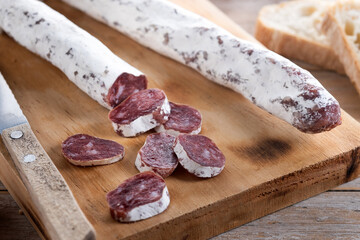 Fuet.Dry cured fuet sausage on wooden table