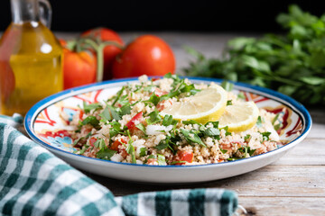 Tabbouleh salad with couscous on wooden table