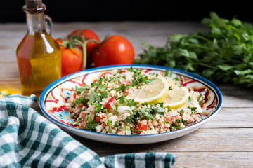 Tabbouleh salad with couscous on wooden table
