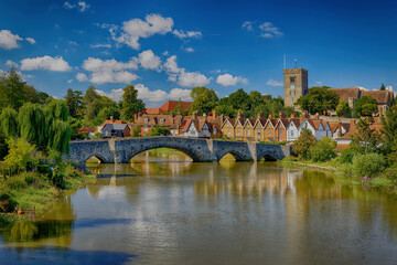 Aylesford Bridge over the river Medway with the Church and village houses under a blue sky with...