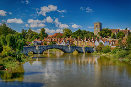 Aylesford Bridge over the river Medway with the Church and village houses under a blue sky with white clouds. Aylesford Kent England Uk